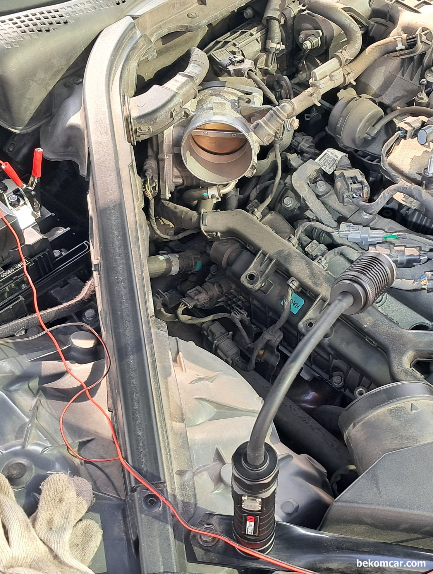 현대자동차 2019년 G80 3.3L GDI 쓰로틀바디 청소 및 학습값 리셋, 현대자동차 2019년 G80 3.3L GDI 쓰로틀바디 청소 및 학습값 리셋기록으로, 엔진룸에서 에어억 등을 탈거후에 쓰로틀바디 모습이다. 버터플라이라는 플랩과 실린더  가장자기에 카본이 많이 보인다.|بيكومكار  (bekomcar)