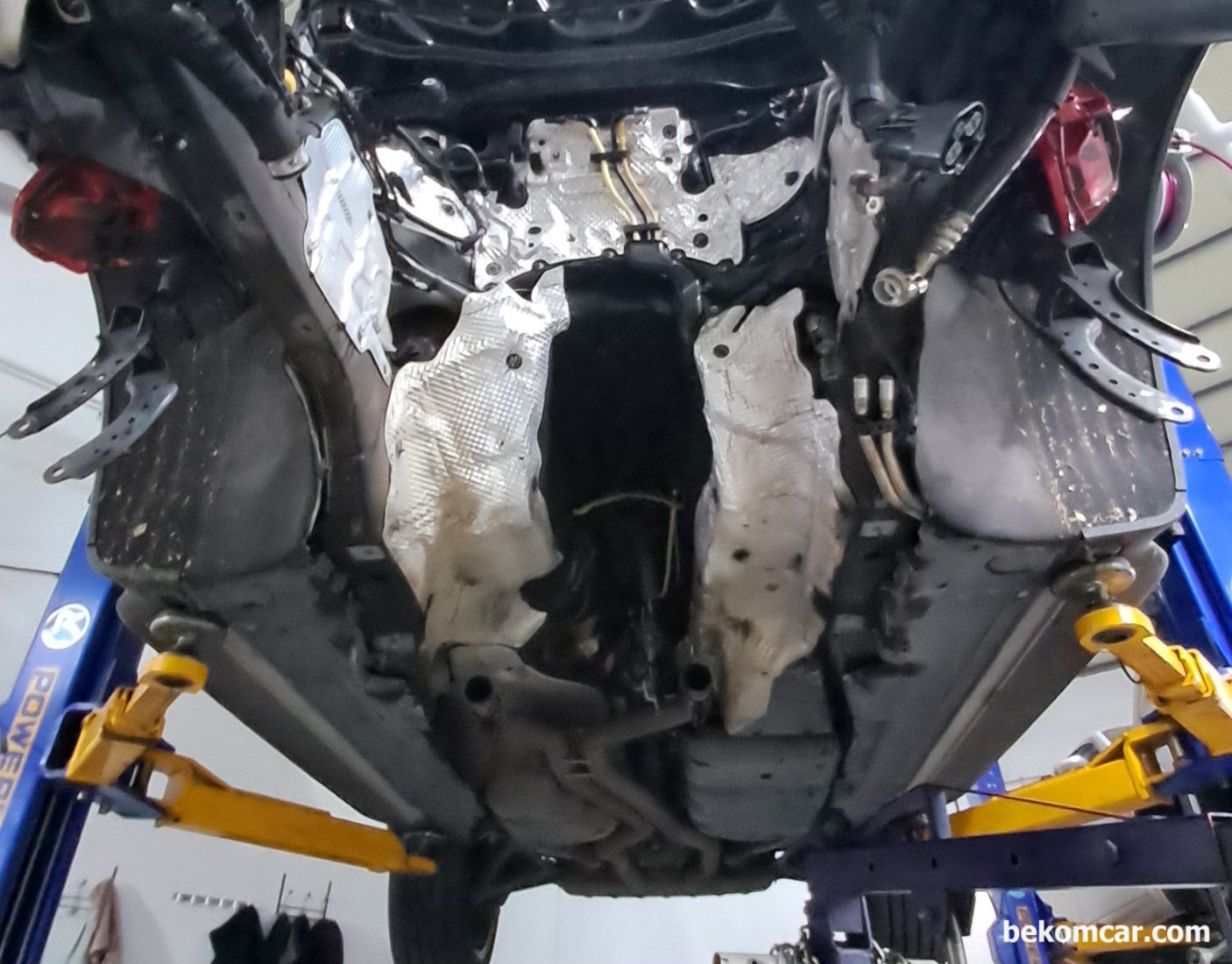 포르쉐 카이엔 엔진룸 뱅크2, 엔진 미션 토크컨버터 위치등 참고자료, 포르쉐 카이엔 리프트에 올려진 상태에서 엔진을 통채로 내린 상태이다. 가운데다 텅 비어있다. 엔진블럭 피스톤등 고장이 있는 경우에는 엔진을 내려서 작업한다.|بيكومكار  (bekomcar)